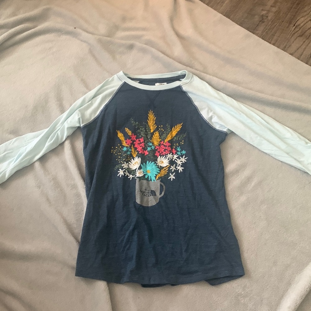 A girls  10/12  shirt has flowers on it and the sleeves are half sleeves